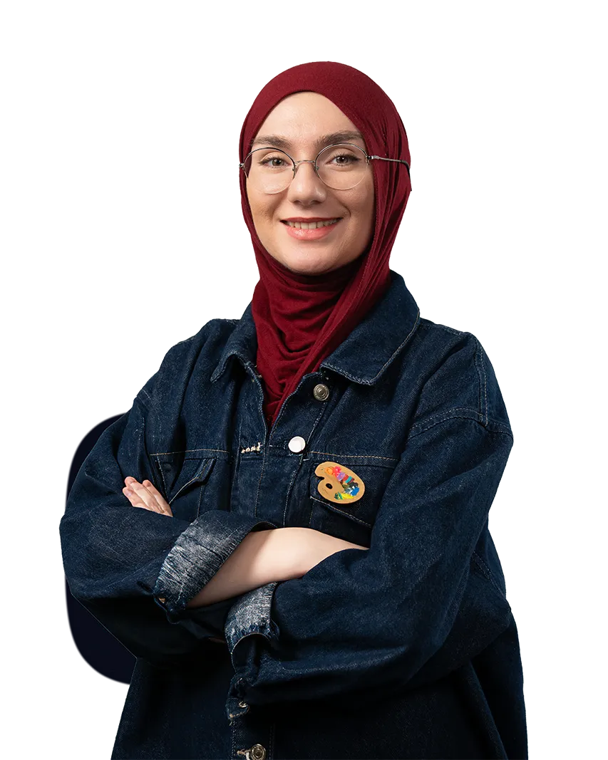 Woman wearing a red hijab, glasses, and a dark denim jacket with an artist palette pin, smiling with arms crossed.